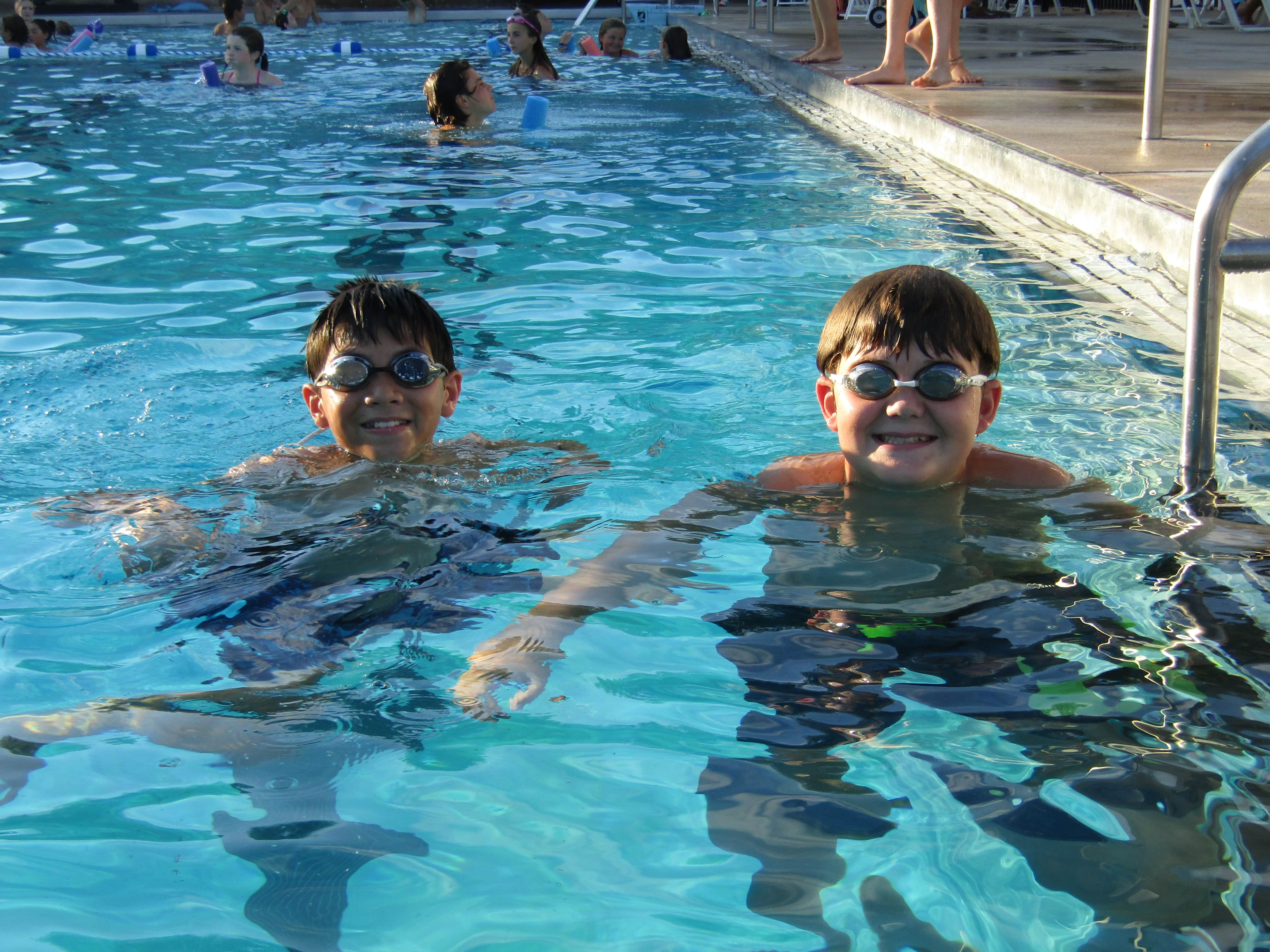 two kids in pool looking at camera